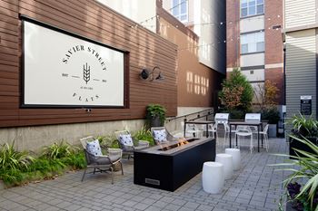 a patio with tables and chairs and a coffee shop on the side of a building